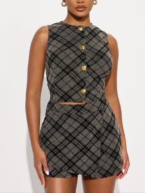 A tweed two-piece suit consists of a fitted vest and a short skirt